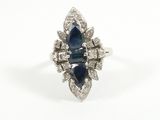 a close up of a diamond and sapphire ring on a white background