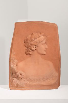sculpture représentant une tête de femme posée sur une étagère blanche dans une pièce blanche