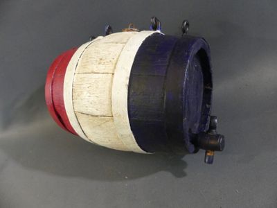 a red, white, and blue barrel on a gray surface