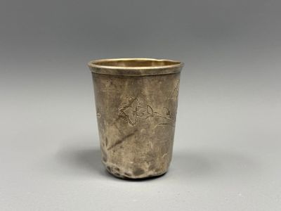une vieille coupe en argent posée sur une table blanche