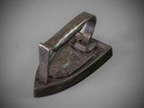 a close up of a metal iron on a white surface