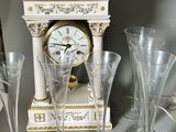 a clock that is sitting on a table next to some wine glasses