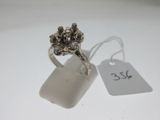 une photo d'une bague en argent posée sur une surface blanche, avec une étiquette de prix