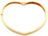 a close up of a gold heart shaped bracelet on a white background