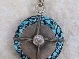 a blue and silver pendant with a cross on it
