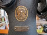 a close up of a sewing machine with a medallion on it