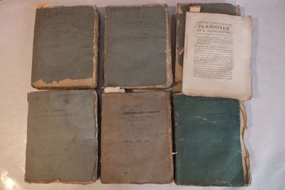 six vieux livres empilés les uns sur les autres sur une table