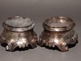 pair of antique silverplated candlesticks on stand on grey background