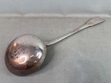 a silver spoon with a spoon handle on a table