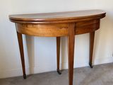 une petite table avec un plateau en bois, montée sur roulettes, dans une pièce