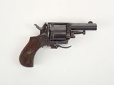 un vieux revolver avec une poignée en bois sur une surface blanche