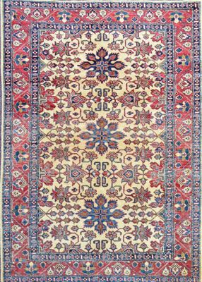 an antique persian rug with a floral design on a cream ground