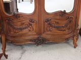 a wooden armoire with two mirrors on top of it