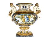 un grand vase avec un tableau posé sur une table