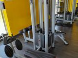 a row of machines in a gym room with yellow walls