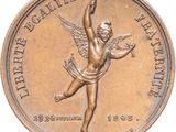 an image of a bronze medal with a winged figure on it