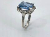 an image of a ring with a blue stone surrounded by diamonds