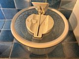 a plastic container with a lid on a tiled floor