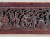 une vieille plaque en bois sur laquelle sont sculptés des personnages et des animaux