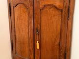 a wooden cabinet with a pink vase on top of it