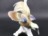 a figurine of a bird sitting on top of a branch