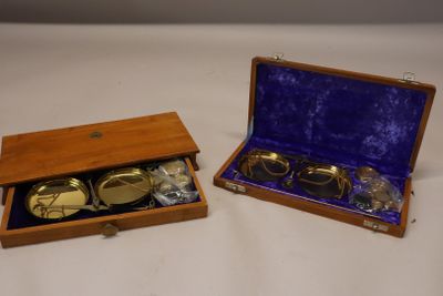 une paire de lunettes plaquées or dans un coffret en bois, posée sur une surface blanche