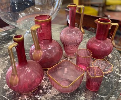 beaucoup de vases et de verres en verre rose posés sur une table
