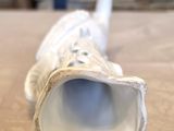 a close up of a white vase on a table