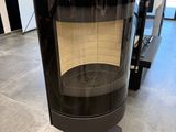 un poêle noir posé dans une pièce dotée d'une grande fenêtre