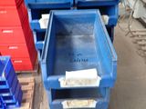 several blue plastic containers are stacked on a pallet in a warehouse