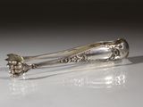 une cuillère en argent ornée d'une fleur, posée sur une table