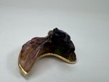a picture of a figurine of a black cat sitting on a leaf
