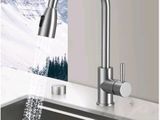 un gros plan d'un évier de cuisine avec un robinet d'où coule de l'eau