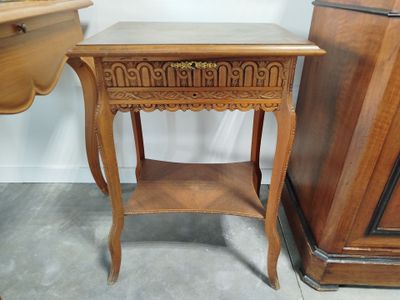 une petite table avec un tiroir, placée à côté d'une commode