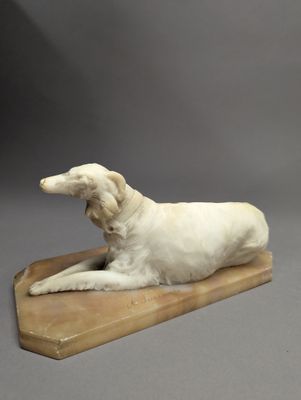 sculpture représentant un chien blanc couché sur une planche de bois, sur fond gris