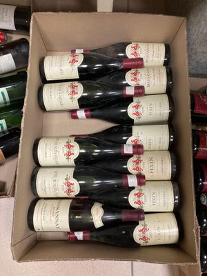 des bouteilles de vin sont posées dans un carton posé par terre