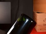 a bottle of wine sitting on a table next to a laptop