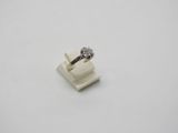 a white ring with a diamond on top of it on a white surface