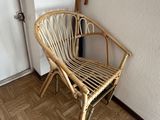 a wicker chair and umbrella in the corner of a room