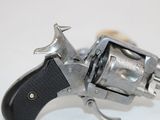 a silver revolver with a black handle on a white surface