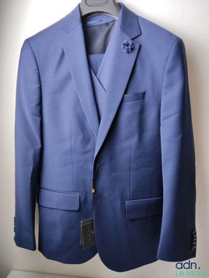 the jacket is blue and has a flower on the lapel