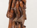 wooden statue of a man holding a child on his back