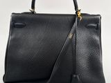 a black leather handbag on a white background
