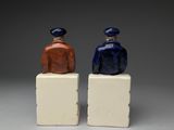 pair of ceramic figurines of two men sitting on blocks