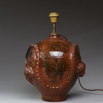 une image représentant un vase marron surmonté d'une lampe