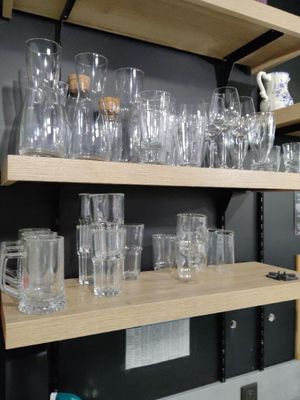 de nombreux verres et tasses sur les étagères de la pièce