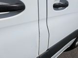 a white van with black trims parked in a parking lot