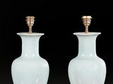 pair of white and gold vases sitting on a red surface