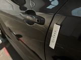 a sticker on the door handle of a black car