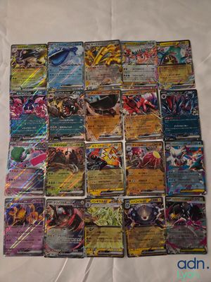 a close up of a pile of pokemon cards on a bed